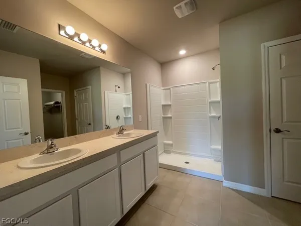 a bathroom with a double vanity sink and a mirror