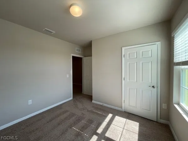 an empty room with windows and closet