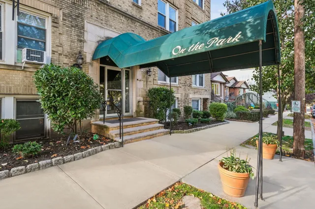 a backyard of a house with potted plants and large tree