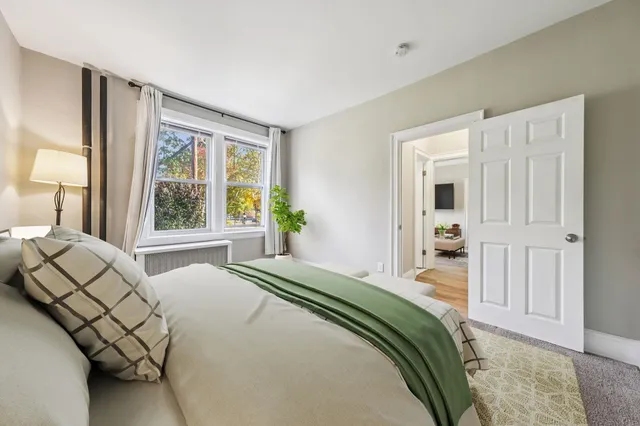 a bedroom with a bed and a large window