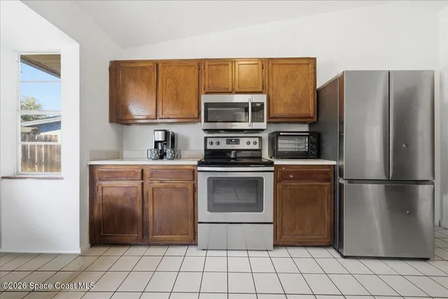 a kitchen with a sink a stove top oven and cabinetry