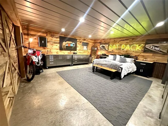 a kitchen with stainless steel appliances kitchen island granite countertop a table chairs and a refrigerator