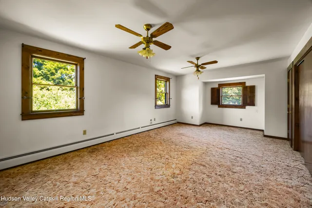 a view of a livingroom with a ceiling fan and window