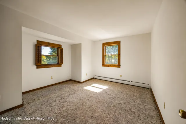 an empty room with windows and closet
