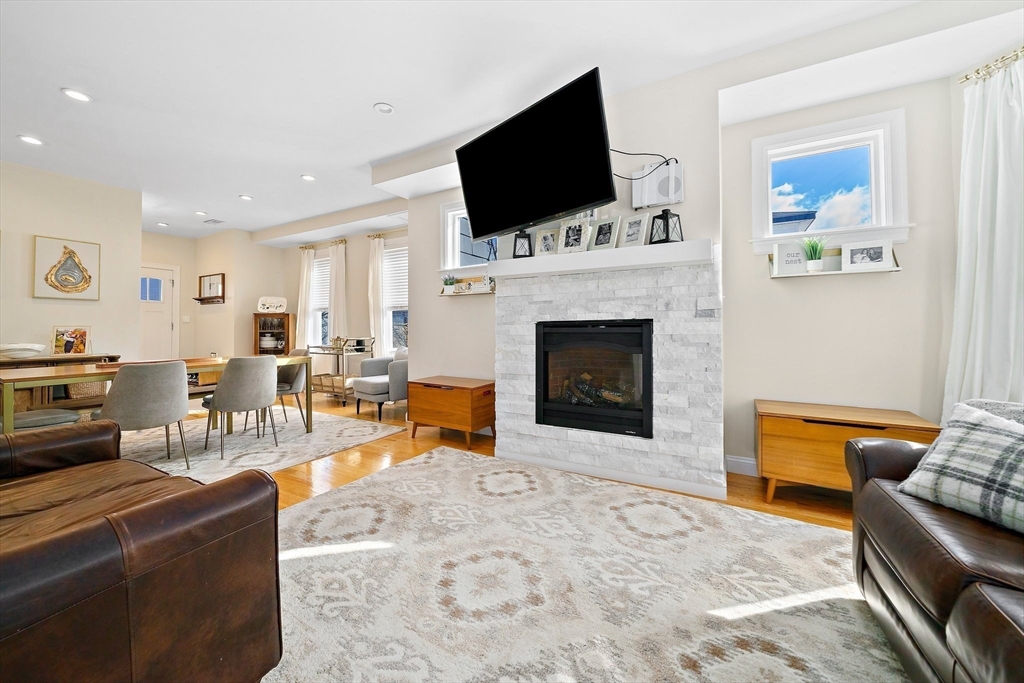 11 Mason Street, Unit 2 Everett, MA 02149 - Photo 2 of 12 a living room with furniture a flat screen tv and a fireplace