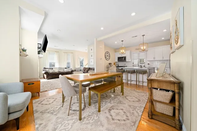 a dining hall with stainless steel appliances kitchen island granite countertop a dining table and chairs