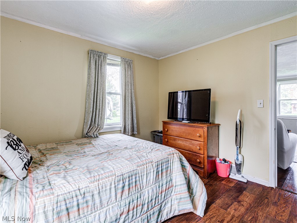 850 Ridgeview Drive Independence, OH 44131 - Photo 12 of 20 Bedroom featuring a textured ceiling, dark hardwood / wood-style flooring, and crown molding