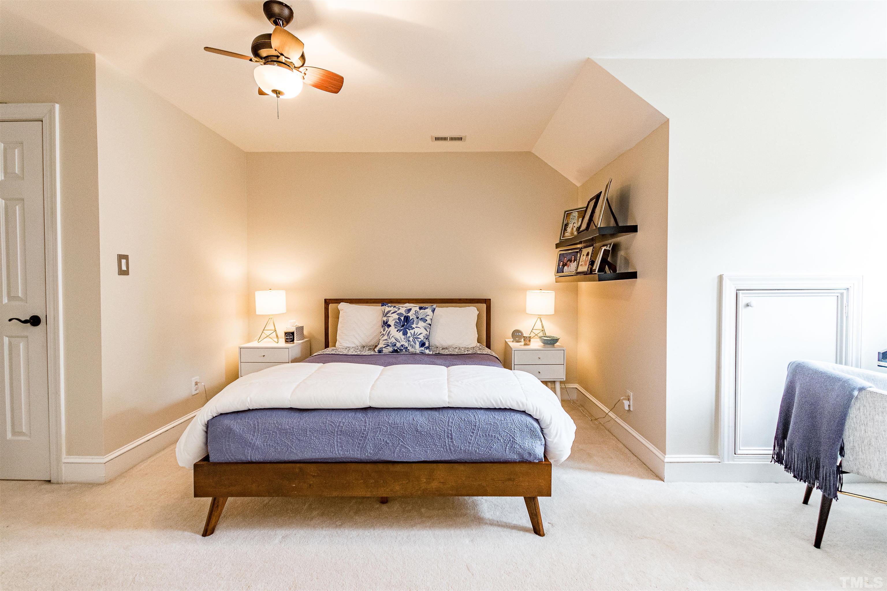 7631 Wellesley Park North Raleigh, NC 27615 - Photo 48 of 88 a bedroom with a bed and a chandelier