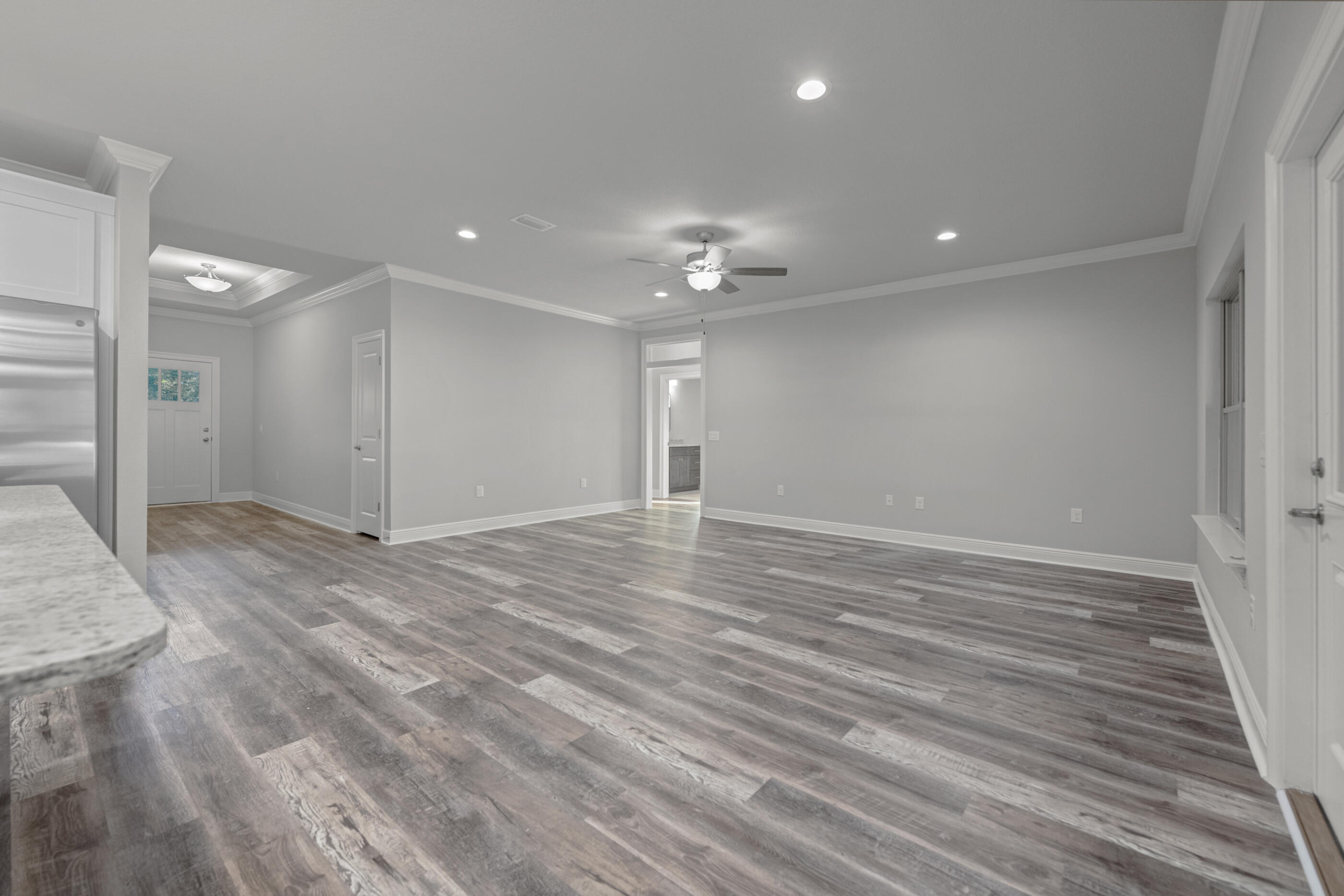 6699 Rocky Shores Road Milton, FL 32583 - Photo 13 of 77 an empty room with wooden floor and a ceiling fan