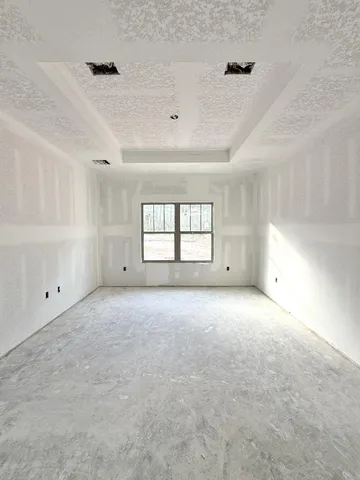 an empty room with a window and ceiling fan