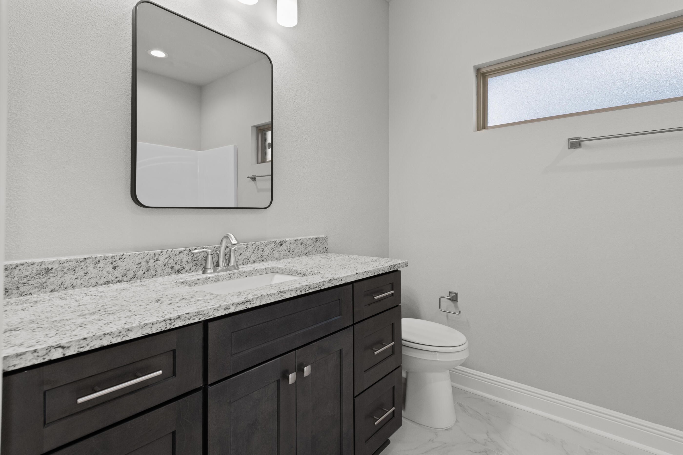 6699 Rocky Shores Road Milton, FL 32583 - Photo 58 of 77 a bathroom with a granite countertop sink a toilet and mirror