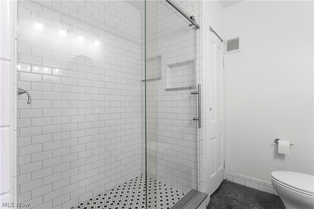 1779 Fulton Road Cleveland, OH 44113 - Photo 10 of 34 Pull the vintage door open to the old cold storage space and you’ll find a bathroom with luxe glass door shower and tile!