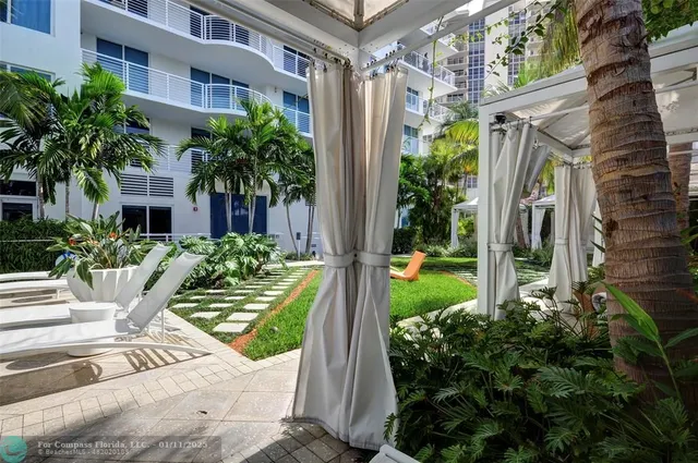 a view of backyard with outdoor seating and plants