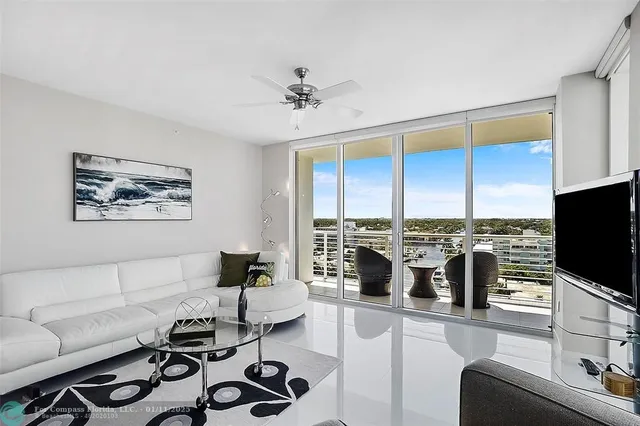 a living room with furniture a flat screen tv and a large window