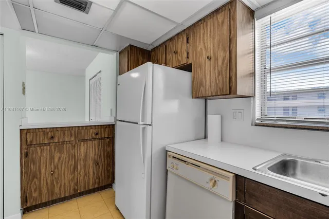 a kitchen with a refrigerator sink and cabinets