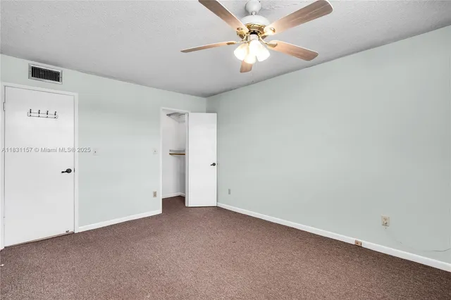 an empty room with a ceiling fan and a window