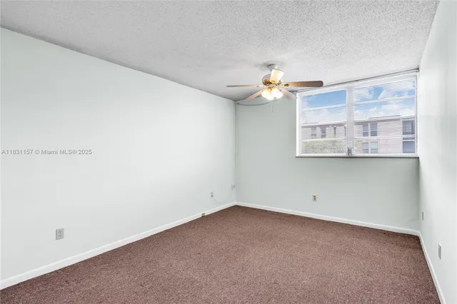a view of a room with a ceiling fan and a window