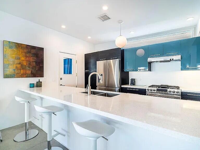 2223 North Magnolia Road Palm Springs, CA 92262 - Photo 13 of 28 a kitchen with stainless steel appliances granite countertop a sink and a refrigerator