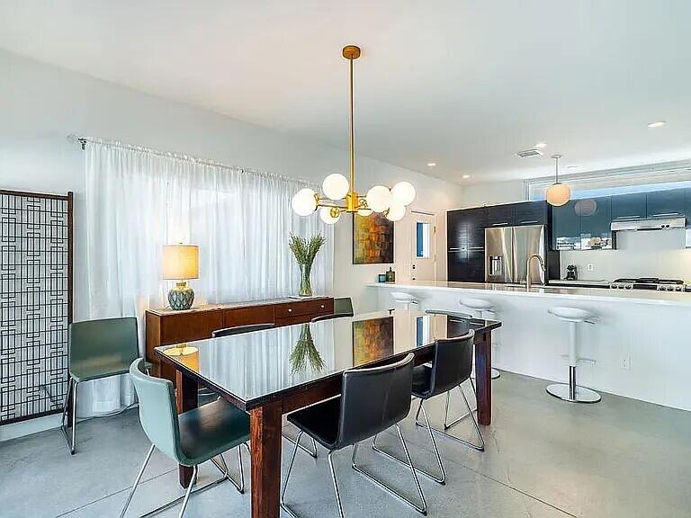 2223 North Magnolia Road Palm Springs, CA 92262 - Photo 9 of 28 a dining room filled chandelier and kitchen view