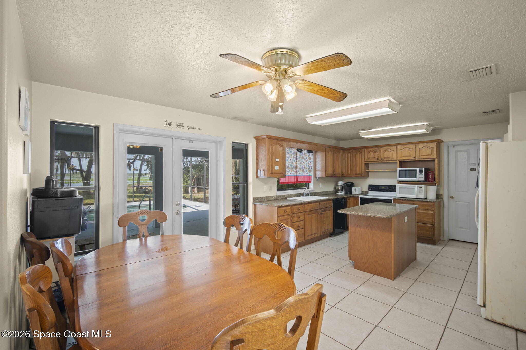 130 North Carpenter Road Titusville, FL 32796 - Photo 18 of 30 Kitchen looking out to Pool Deck