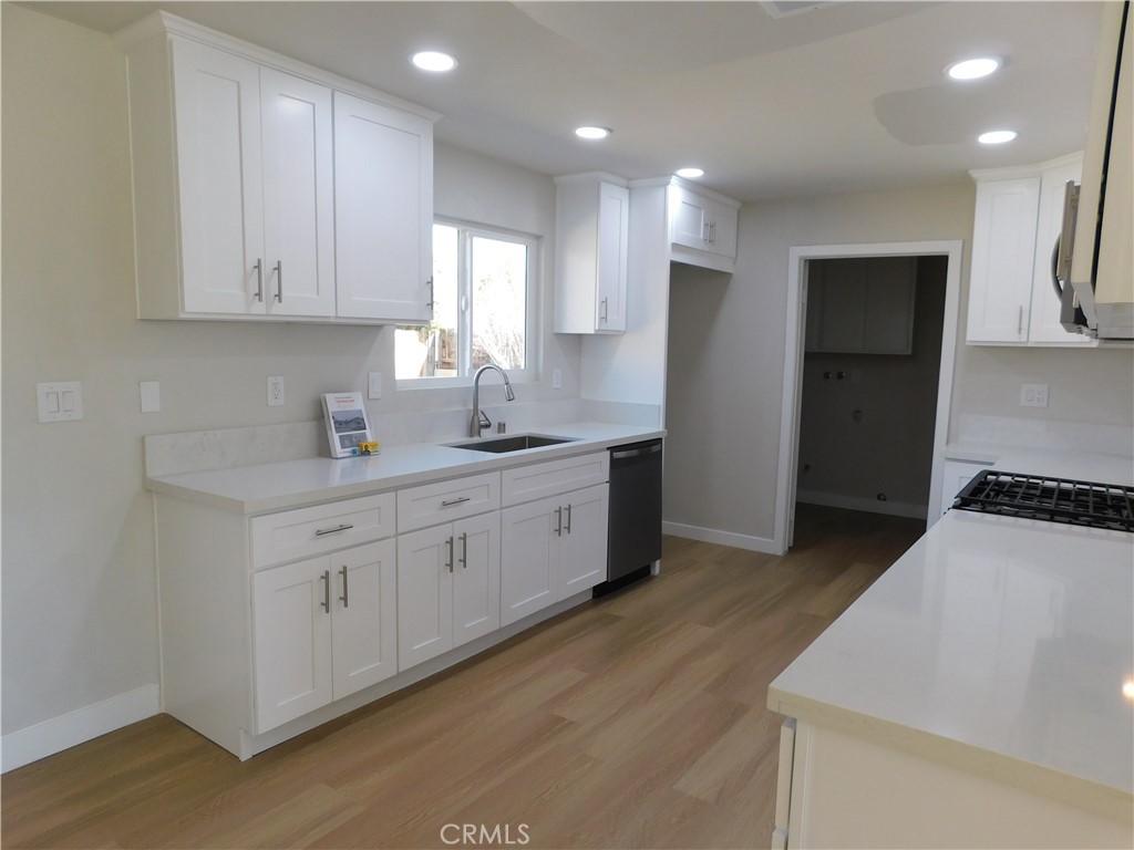 10456 Napa Road Adelanto, CA 92301 - Photo 11 of 31 a kitchen with white cabinets and stainless steel appliances