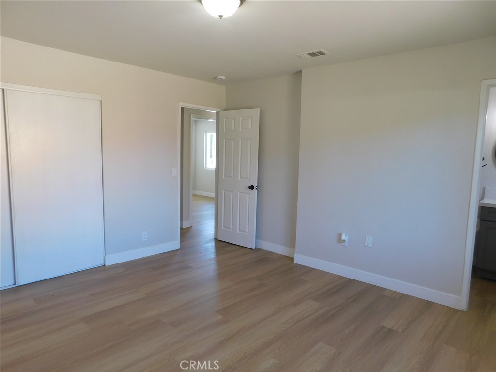 10456 Napa Road Adelanto, CA 92301 - Photo 18 of 31 a view of an empty room with wooden floor