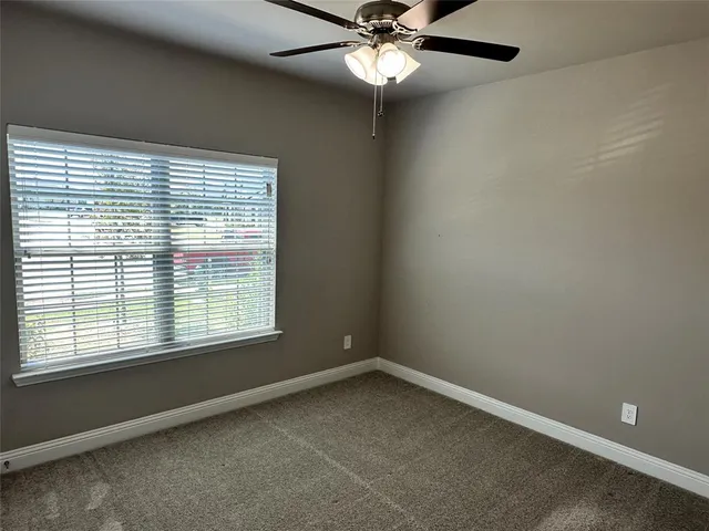 an empty room with closet and a chandelier fan