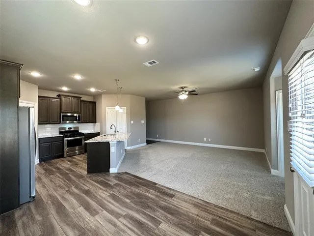 a view of kitchen with refrigerator stove a sink and dishwasher with wooden floor
