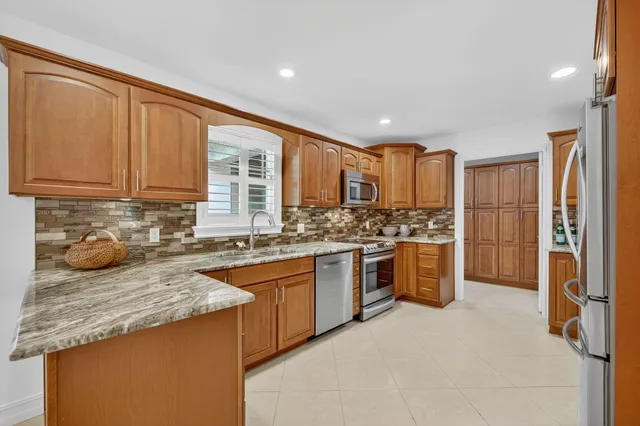 a kitchen with stainless steel appliances granite countertop a stove a sink and a refrigerator
