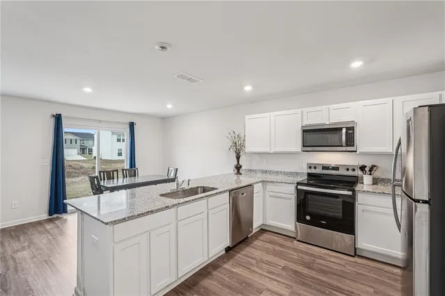 a kitchen with stainless steel appliances granite countertop a sink stove oven and refrigerator
