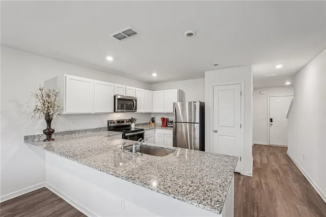 a kitchen with stainless steel appliances granite countertop a sink refrigerator and microwave