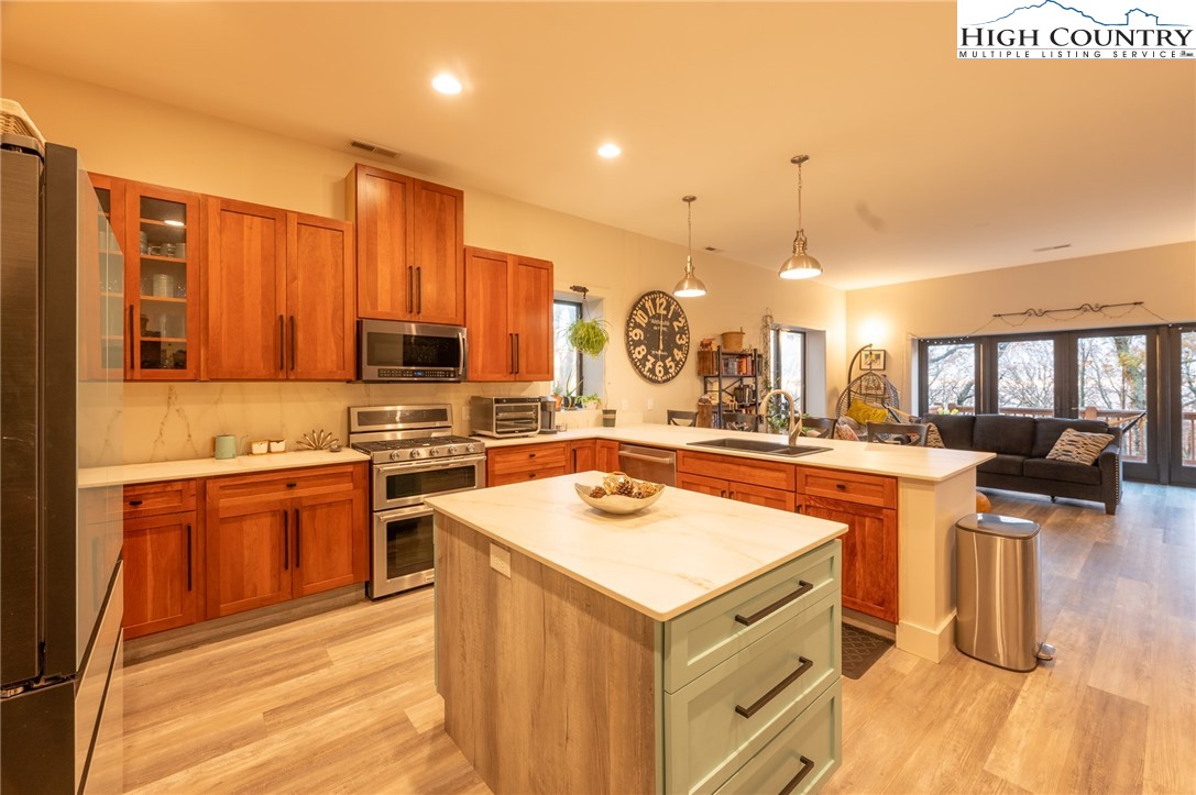 1390 Ransey Woodring Road Todd, NC 28684 - Photo 10 of 48 a kitchen with stainless steel appliances granite countertop a sink a stove and a refrigerator
