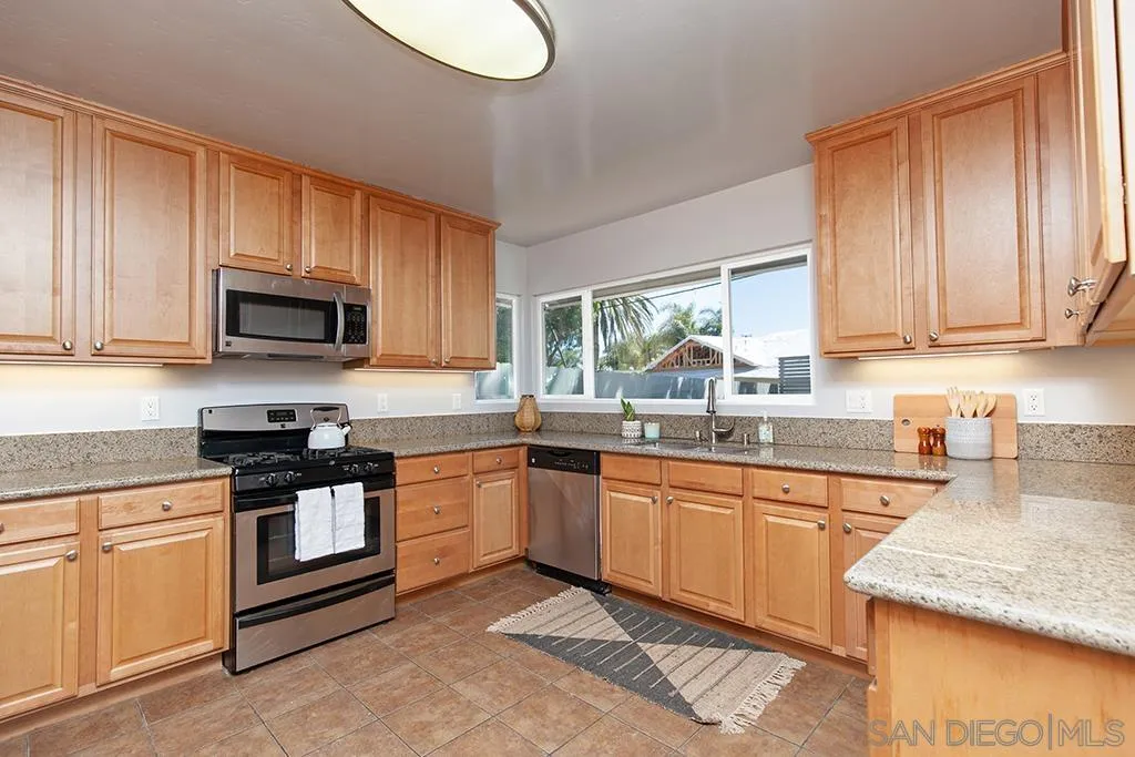 5238 La Jolla Boulevard San Diego, CA 92037 - Photo 16 of 46 a kitchen with stainless steel appliances granite countertop a stove a sink and a microwave