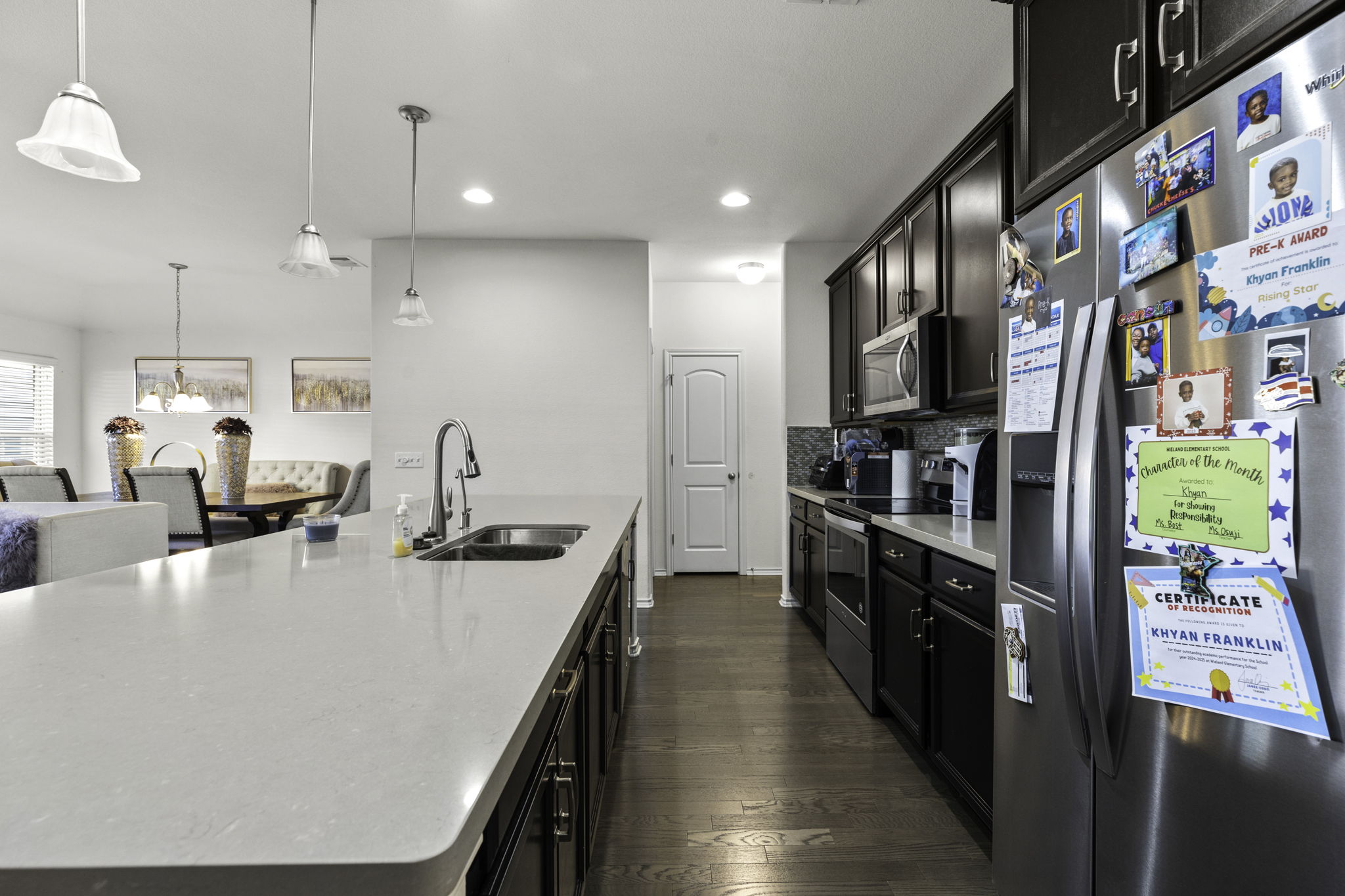 3116 Bragg Place Pflugerville, TX 78660 - Photo 5 of 29 a kitchen with stainless steel appliances granite countertop a sink a stove and a refrigerator