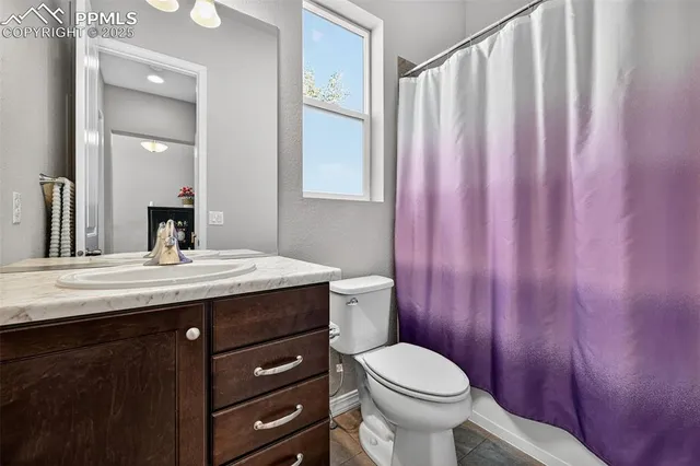 a bathroom with a granite countertop sink toilet and mirror