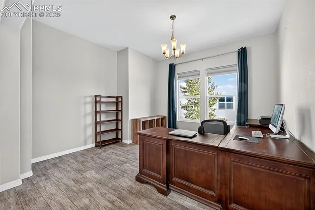 a view of a dining room with furniture a chandelier and wooden floor