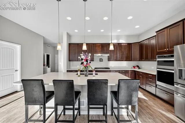 a kitchen with kitchen island granite countertop wooden cabinets and stainless steel appliances