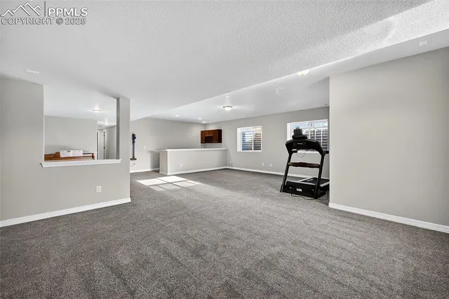 an empty room with white cabinet and mirrors