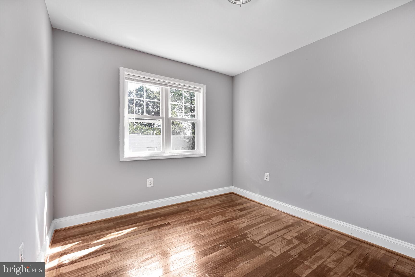 3876 9th Street Southeast, Unit 301 Washington, DC 20032 - Photo 12 of 16 an empty room with wooden floor and windows