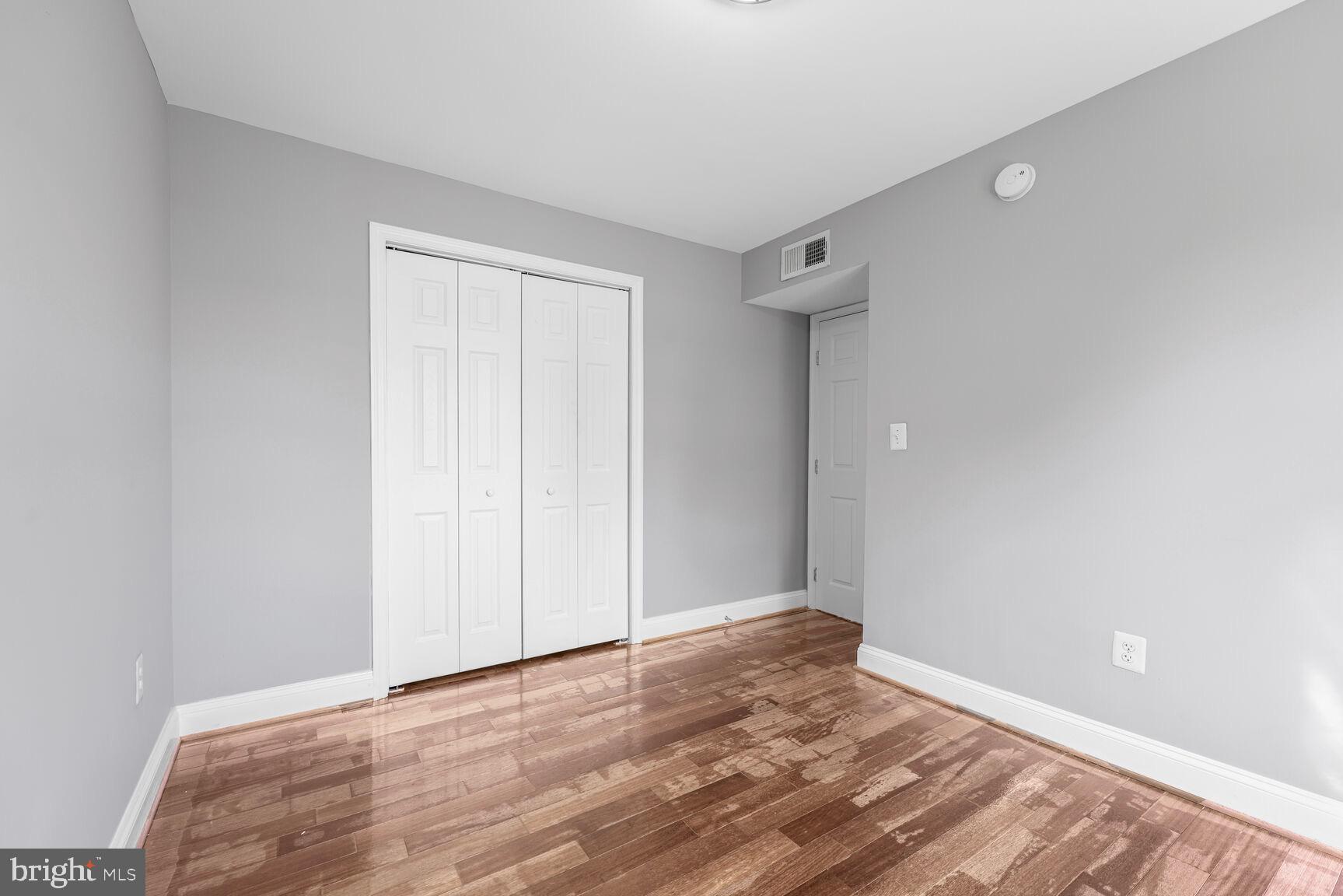 3876 9th Street Southeast, Unit 301 Washington, DC 20032 - Photo 13 of 16 a view of an empty room with wooden floor and a window