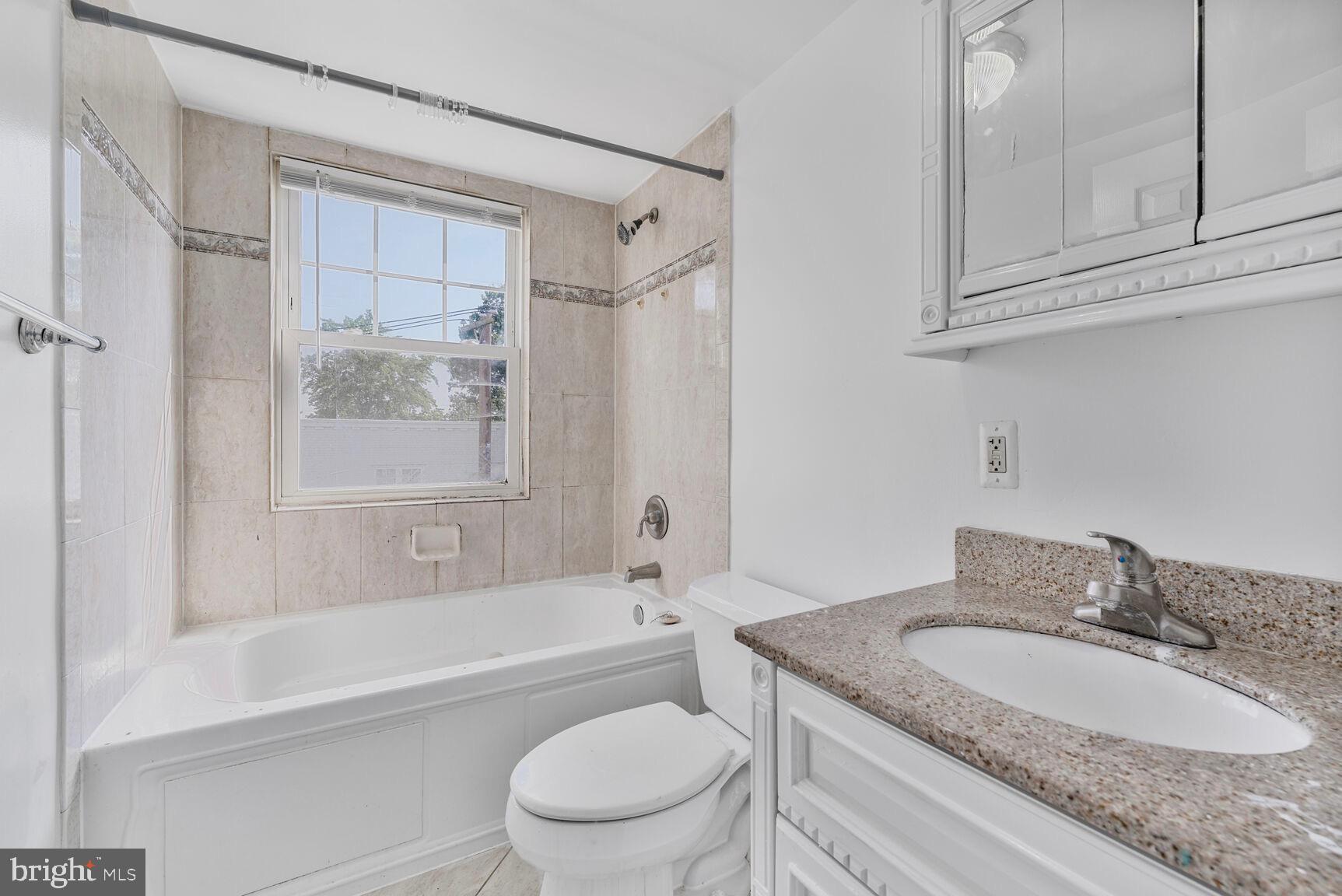 3876 9th Street Southeast, Unit 301 Washington, DC 20032 - Photo 14 of 16 a bathroom with a granite countertop sink toilet tub and shower