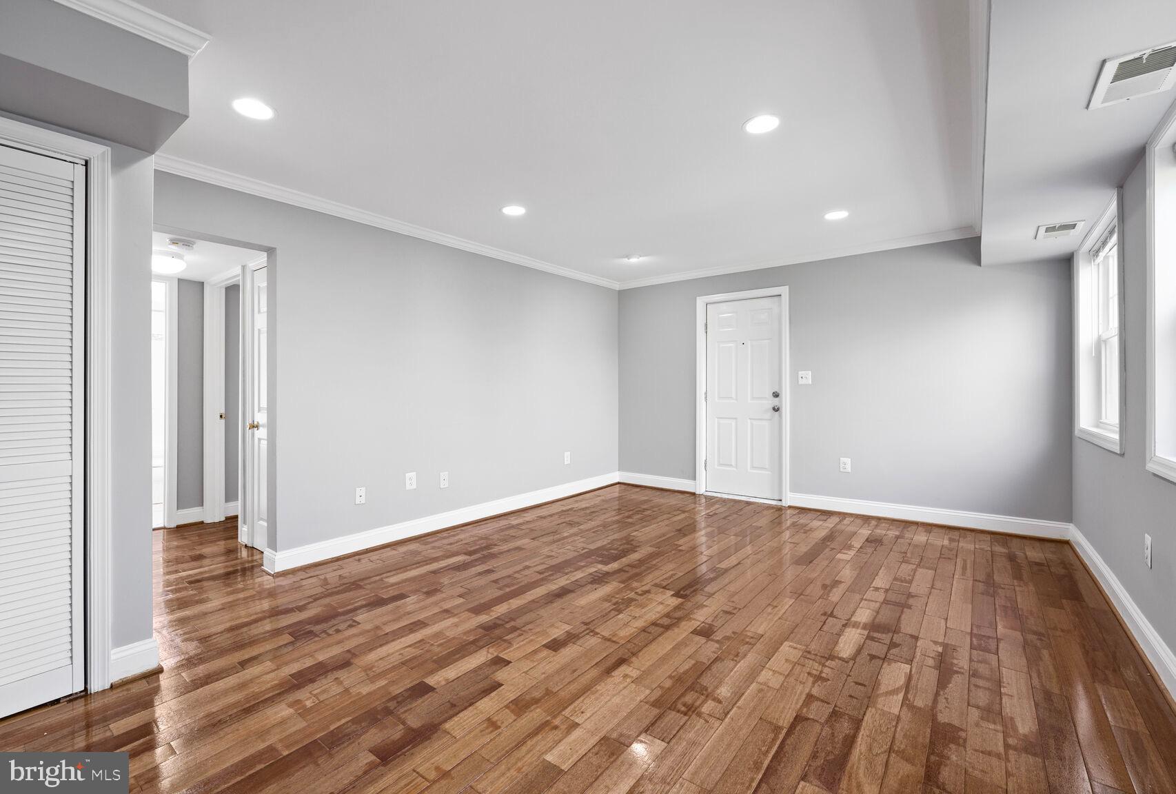 3876 9th Street Southeast, Unit 301 Washington, DC 20032 - Photo 3 of 16 a view of an empty room with wooden floor and a window