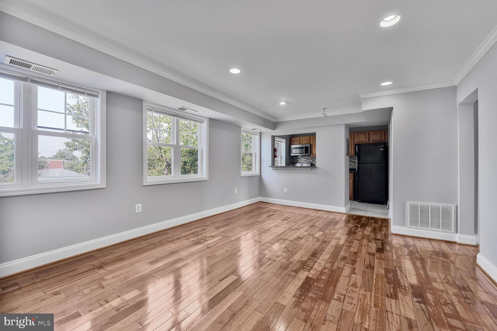 3876 9th Street Southeast, Unit 301 Washington, DC 20032 - Photo 7 of 16 a view of empty room with wooden floor and windows