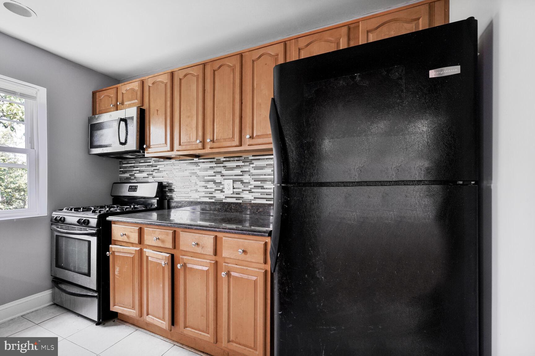 3876 9th Street Southeast, Unit 301 Washington, DC 20032 - Photo 8 of 16 a kitchen with stainless steel appliances granite countertop a refrigerator a stove a sink and a microwave