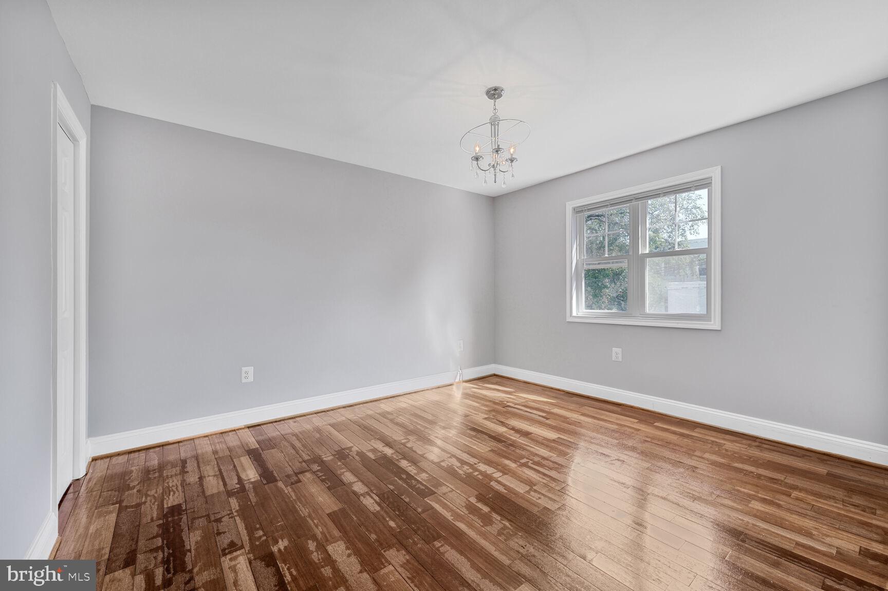 3876 9th Street Southeast, Unit 301 Washington, DC 20032 - Photo 10 of 16 a view of an empty room with window and wooden floor