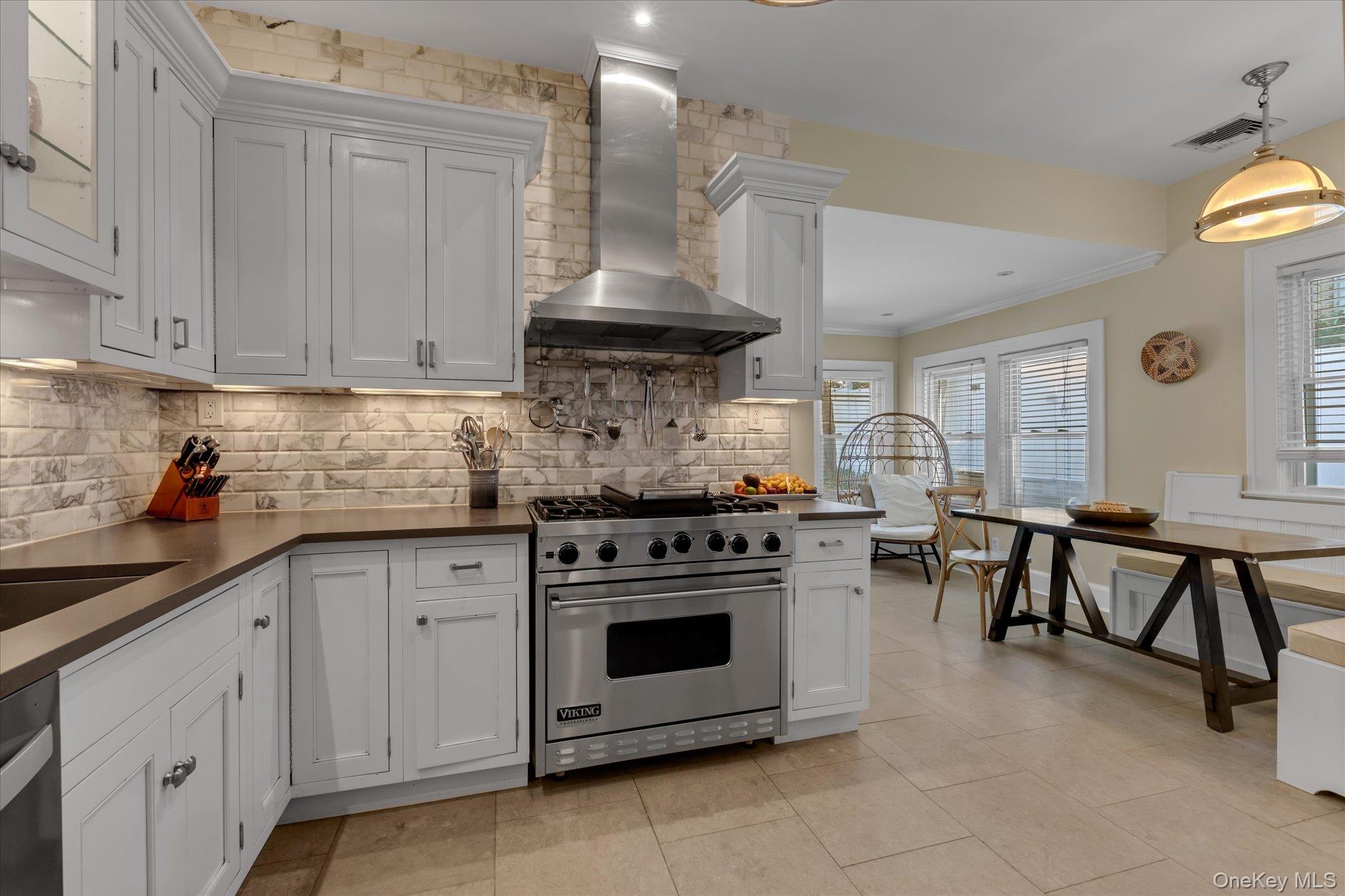 80 Skunks Misery Road Locust Valley, NY 11560 - Photo 11 of 25 a kitchen with stainless steel appliances a stove a sink and white cabinets