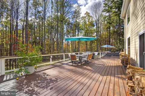 a view of a patio with couches table and chairs and wooden floor