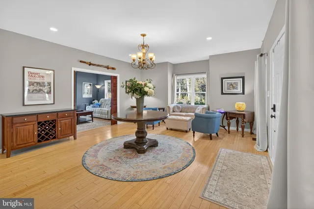 a room with stainless steel appliances kitchen island granite countertop wooden cabinets and a view of living room