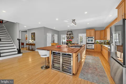 a dining hall with stainless steel appliances a dining table and chairs with wooden floor