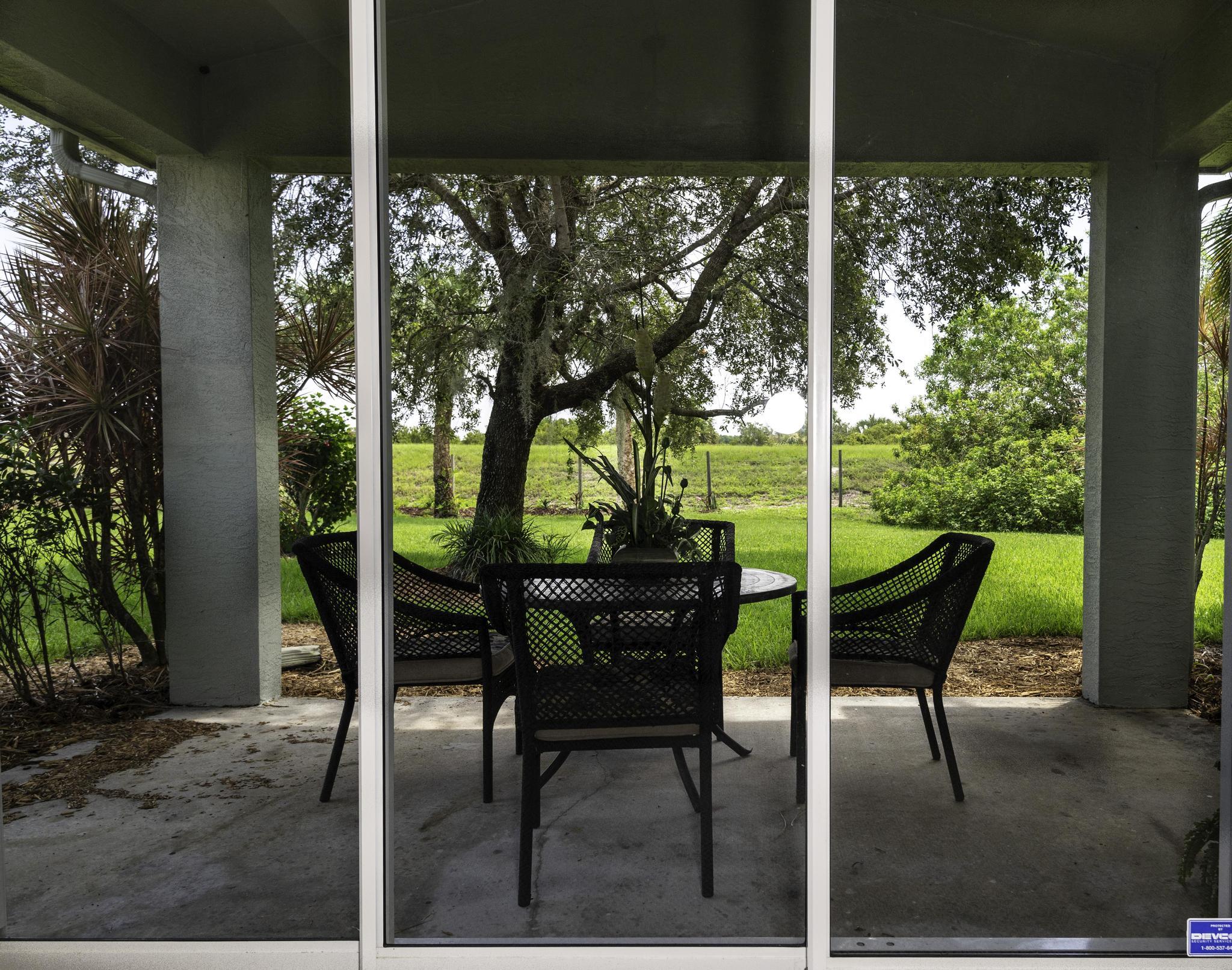 511 Northwest Red Pine Way Jensen Beach, FL 34957 - Photo 12 of 60 a view of a porch with chairs and backyard
